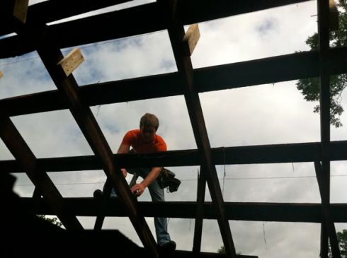 Mennonite at work on bungalow roof.